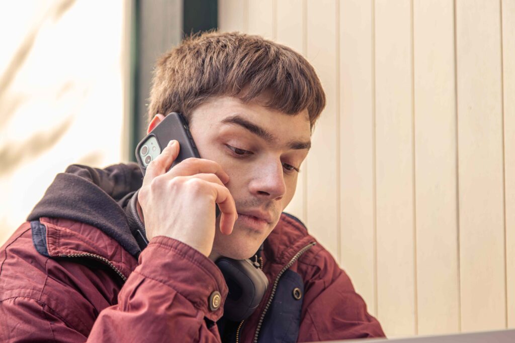 young man talking to parents on phone